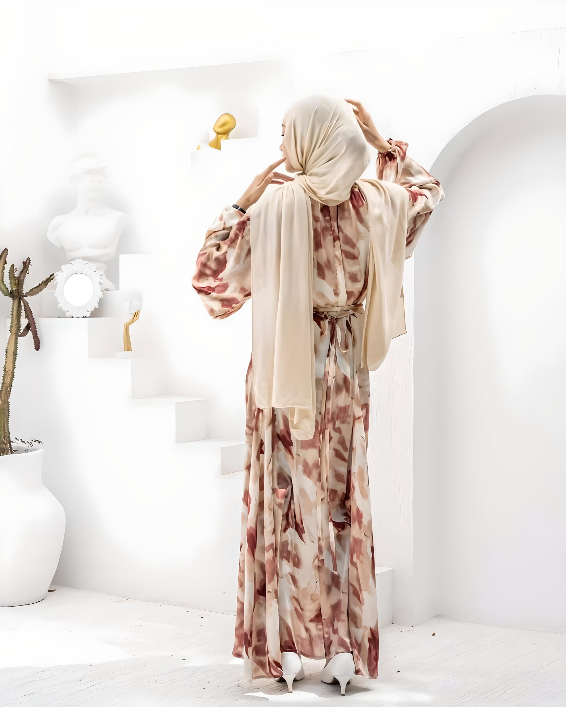Woman wearing an elegant floral print maxi dress with a beige hijab.