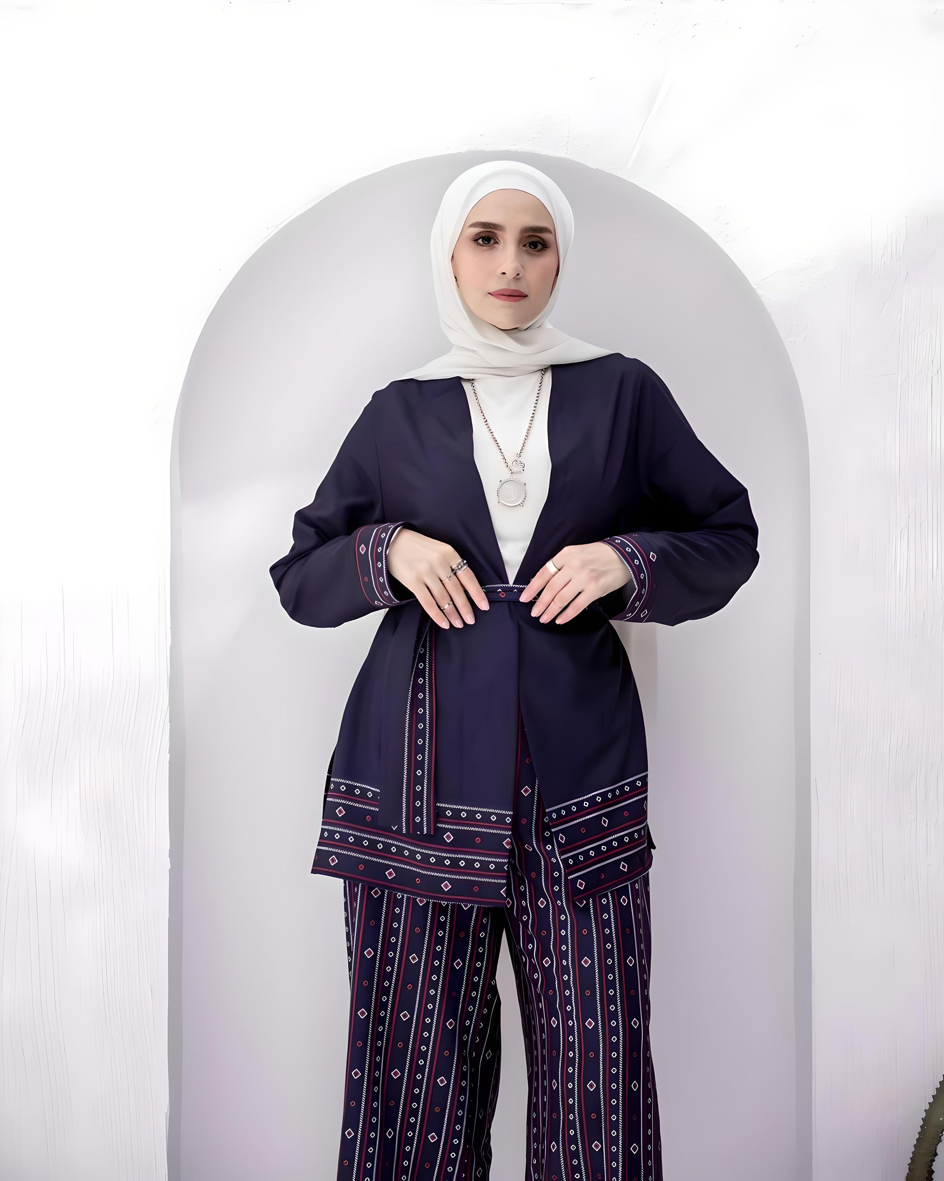 Stylish woman posing in a navy blue suit with red and white patterns.