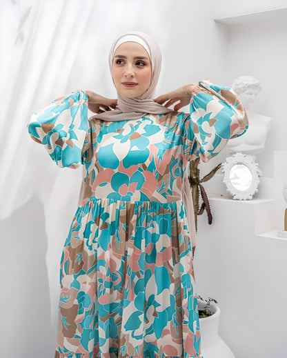 Close-up of blue floral print on maxi dress with beige and pink accents.